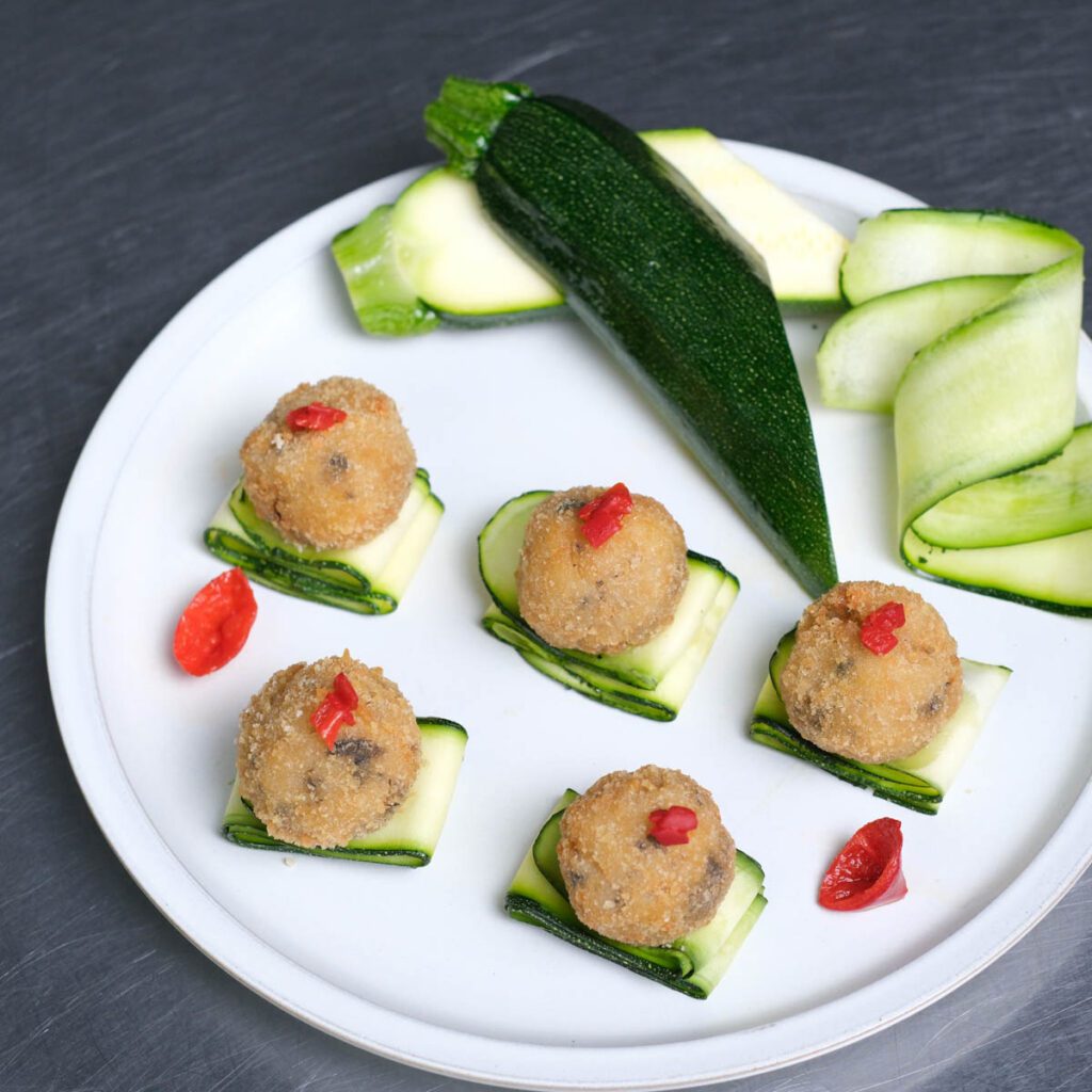 Arancini di Riso over fresh zucchini